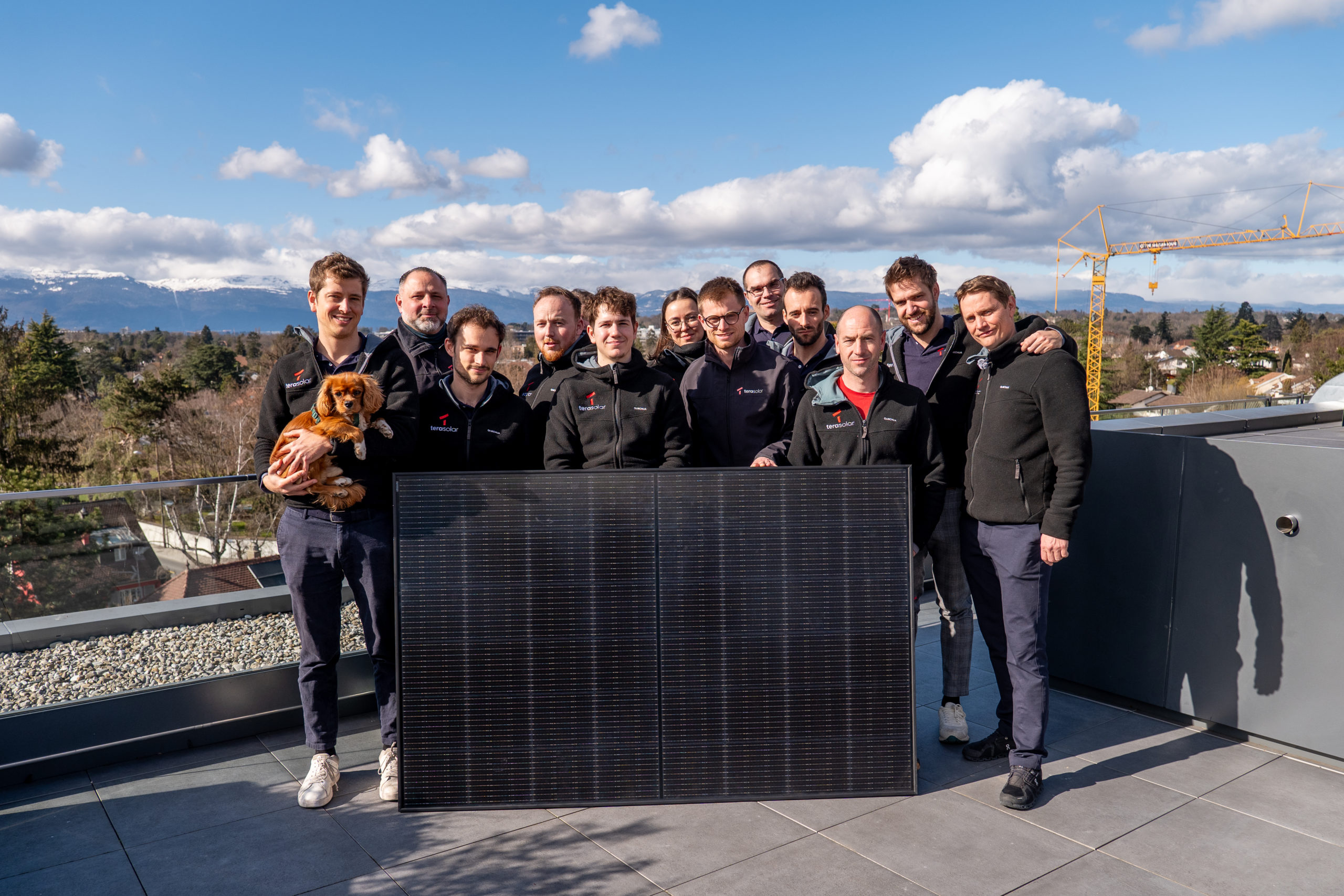 Équipe tera solar souriante avec un panneau photovoltaïque – énergie solaire en Suisse Photo de groupe des collaborateurs de tera solar tenant un panneau solaire, symbolisant l’engagement collectif pour l’énergie renouvelable et la transition énergétique en Suisse.