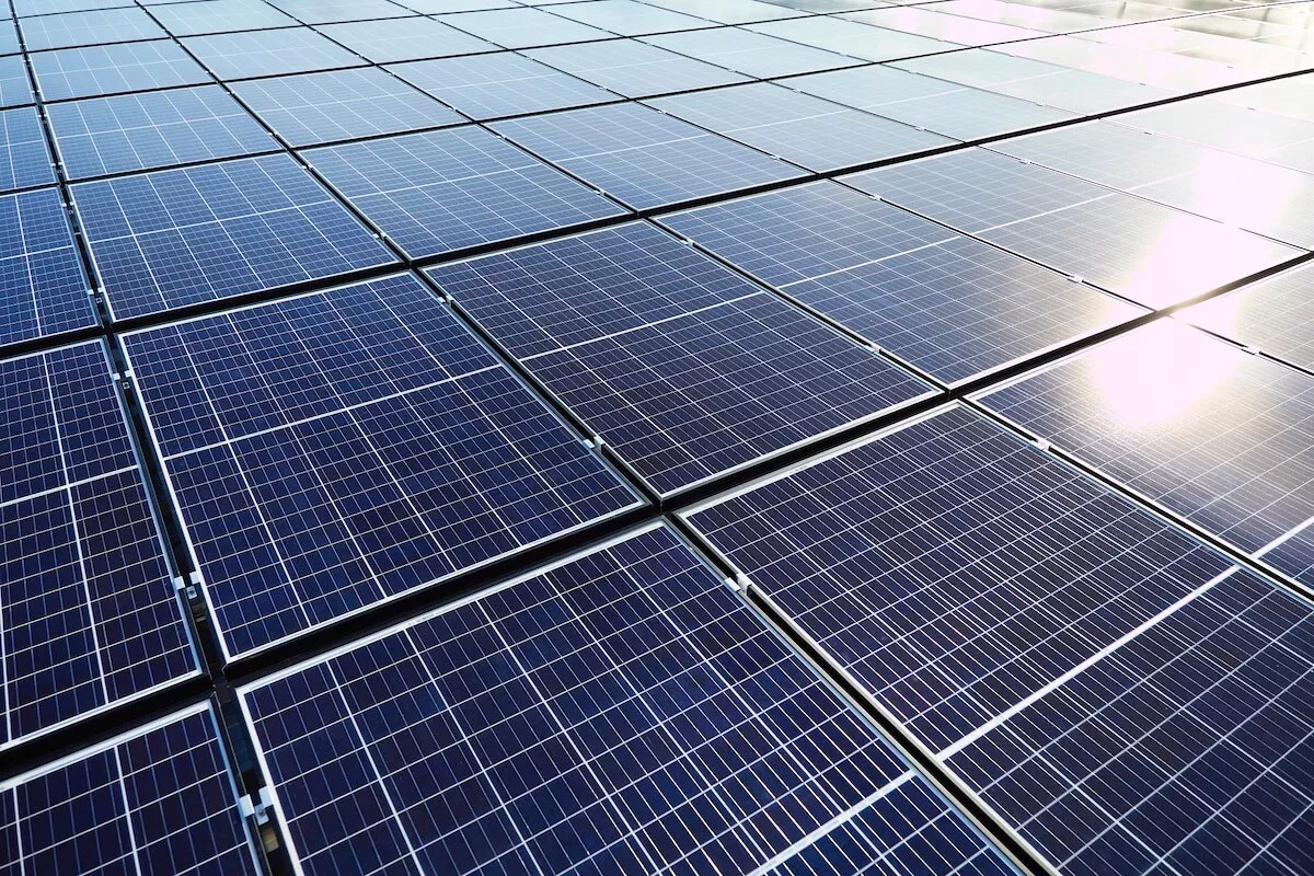 Panneaux solaires avec reflets – Installation photovoltaïque moderne Gros plan sur des panneaux solaires avec reflets visibles, illustrant la qualité d’une installation photovoltaïque en pleine lumière du jour.