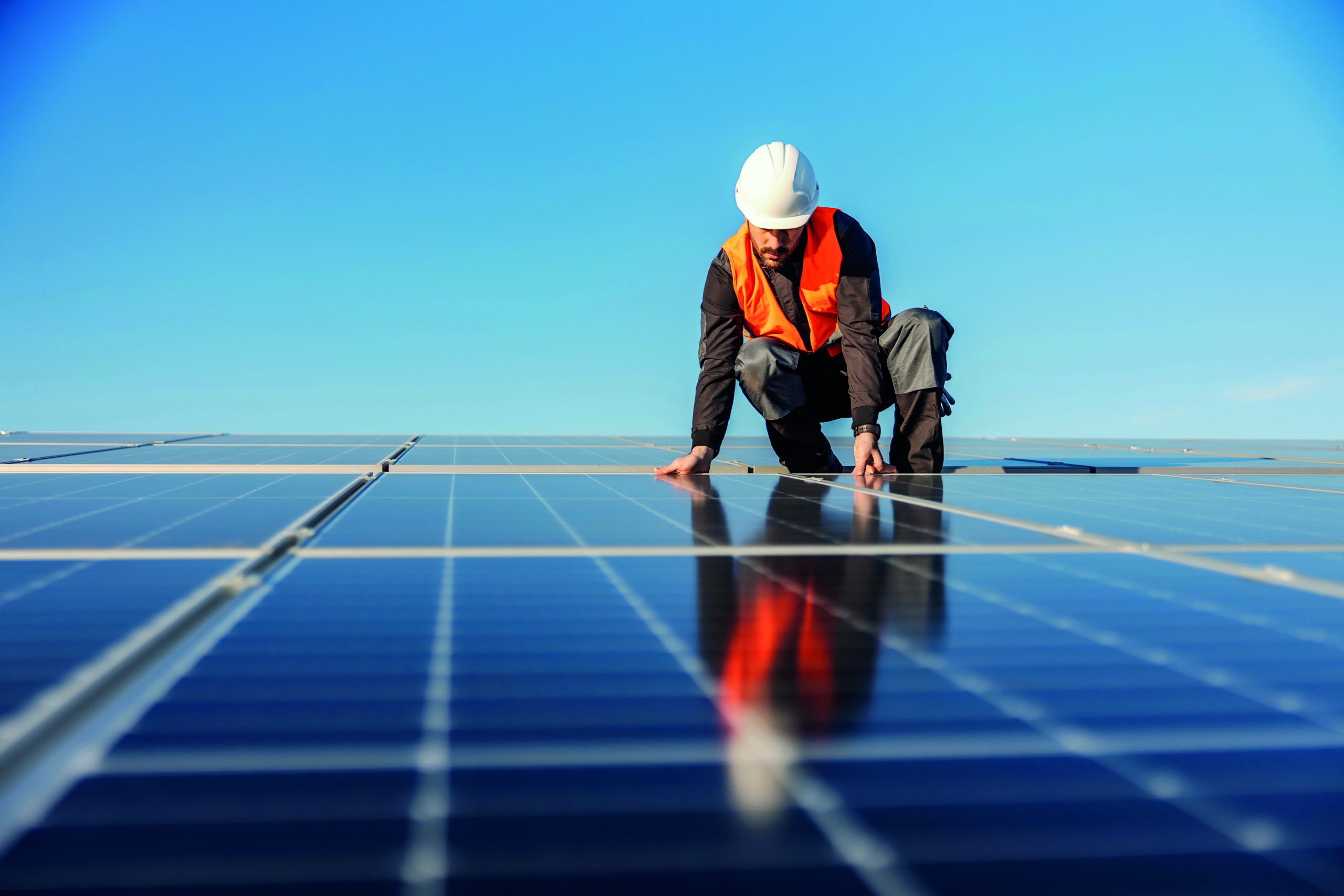 A handyman installing solar panels on the rooftop. Monteur photovoltaïque en train de démonter un panneau photovoltaïque sur une toiture.
